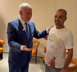 The plumber Yaniv Hayun, right, in the stained T-shirt he was still wearing when he was welcomed home on Wednesday evening