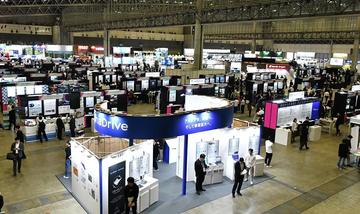 Exhibitors and visitors among the stands in a hall at Makuhari Messe, Chiba